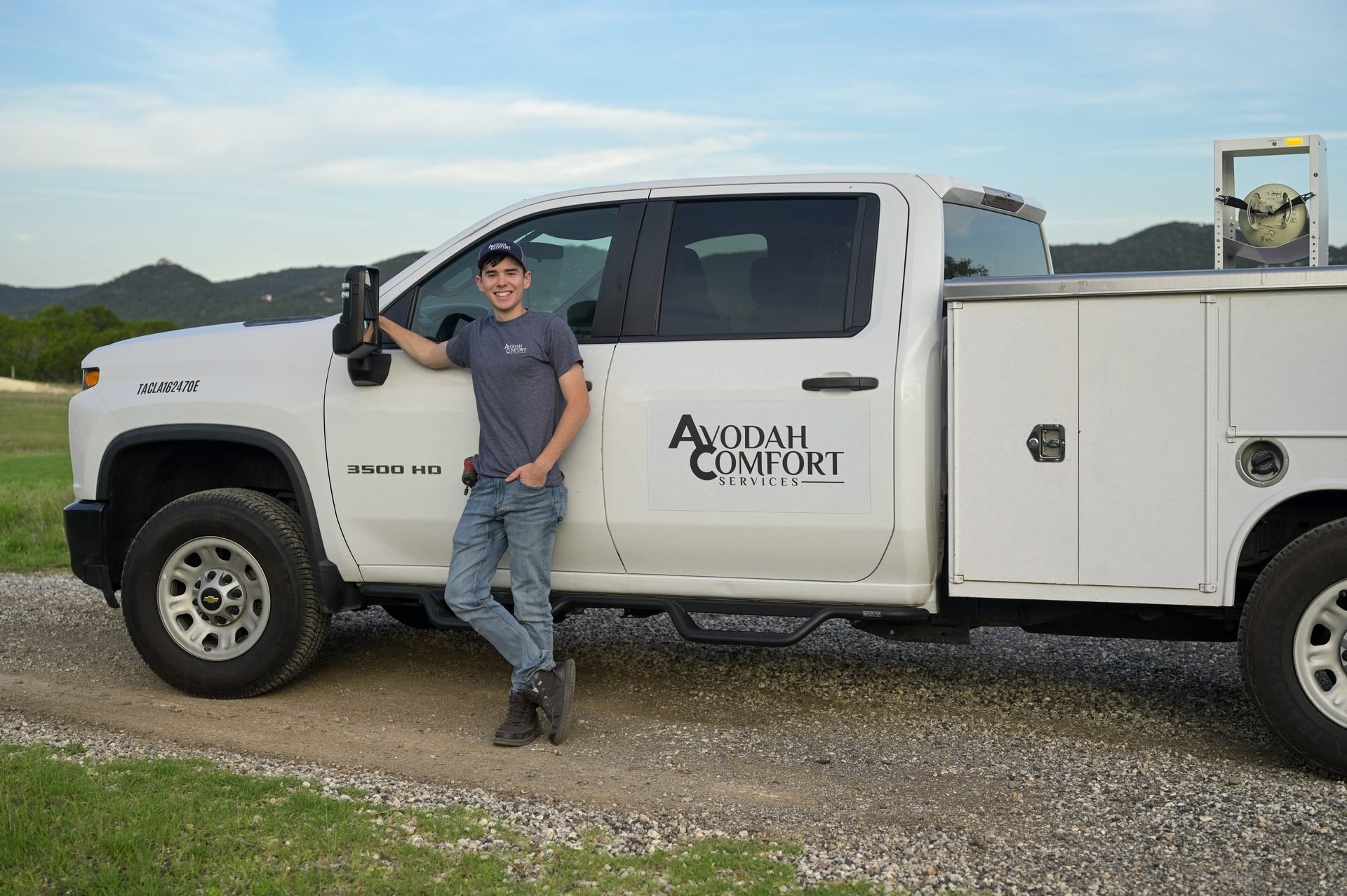 Avodah Comfort Services technician beside the company service truck in the Texas Hill Country